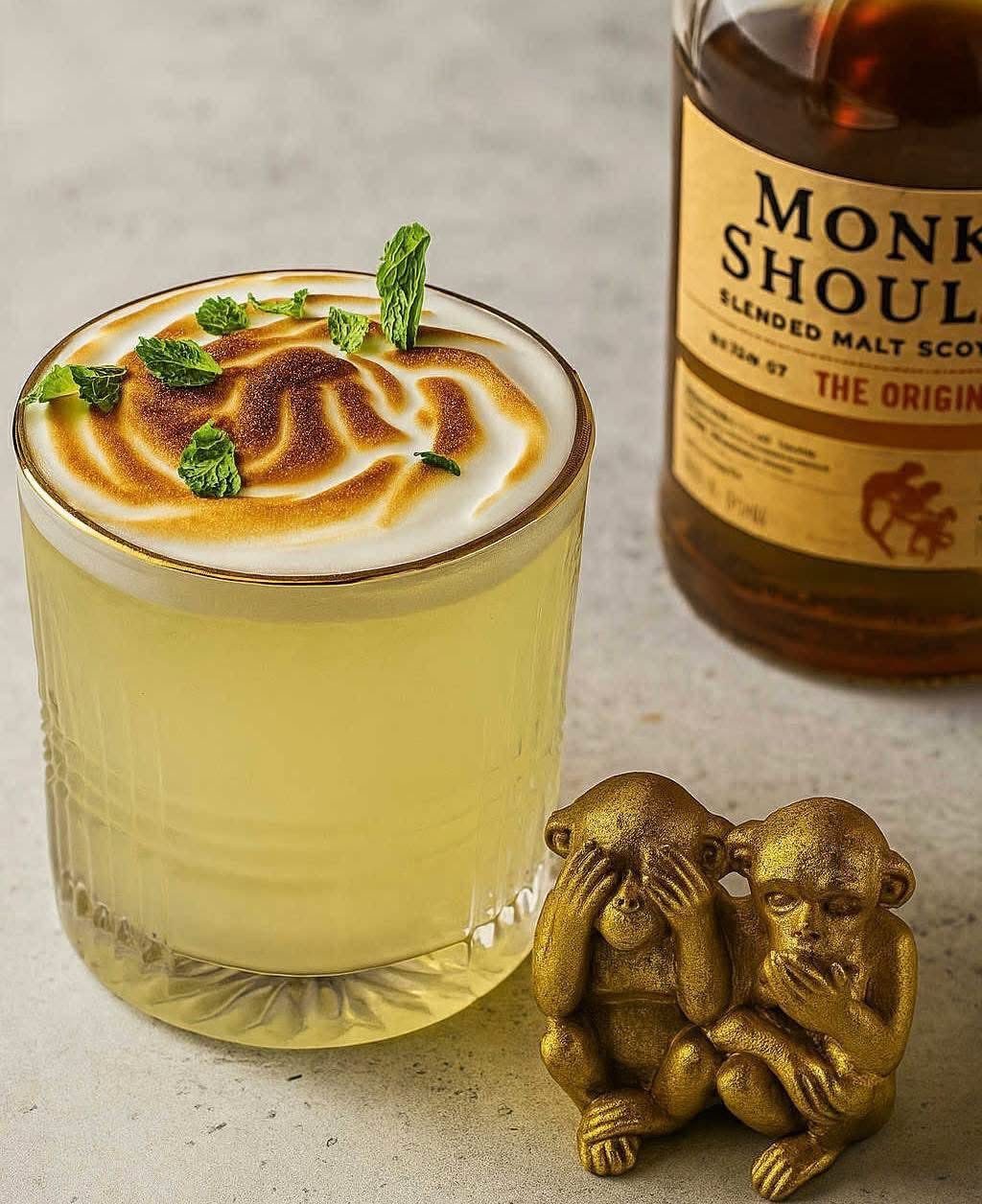 Cocktail signature coiffé d'une meringue flambée et de feuilles de menthe fraîche